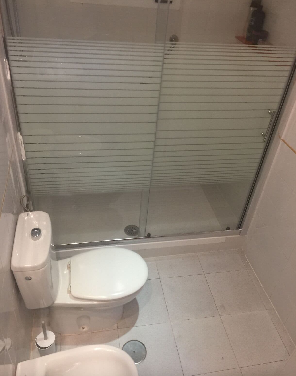 Un bagno piccolo con il water, uno spazio doccia e un lavabo.