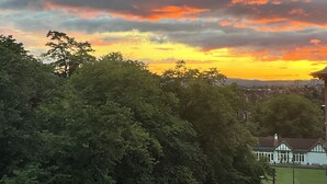Un coucher de soleil avec des nuages au-dessus d’un quartier résidentiel.
