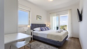 Une chambre à coucher moderne avec un lit, un bureau et de grandes fenêtres.