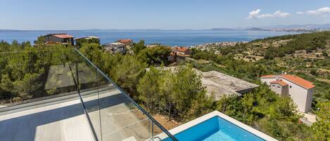 Una piscina en la azotea con vistas despejadas al mar y edificios circundantes.