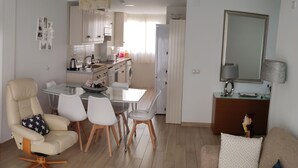 A modern living room with a flat-screen TV, a sofa, and a dining area with a table and chairs. - APARTMENT NEXT TO THE BEACH AND IN THE CENTER OF FUENGIROLA (Fuengirola)