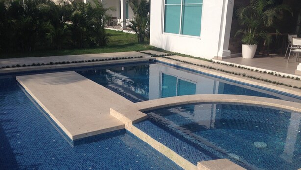 Una piscina rectangular amb un videtrajat i una secció corbada.