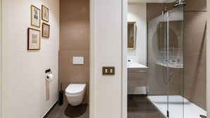Un baño moderno con inodoro, ducha y lavamanos.