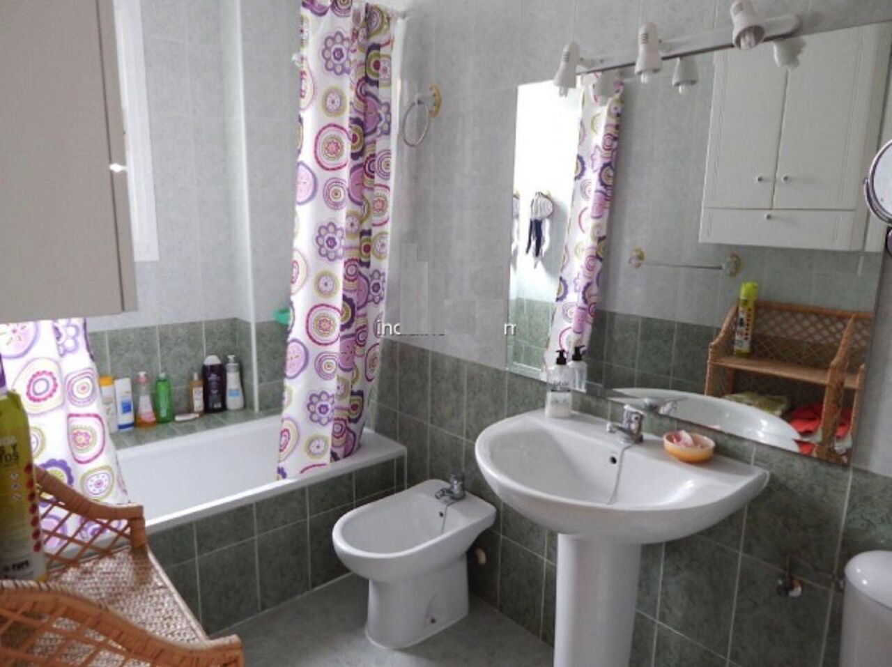 Een badkamer met een bidet, wastafel en bad.
