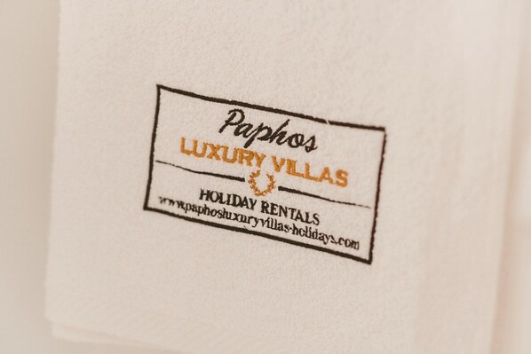 Una etiqueta con el texto 'Paphos Luxury Villas' y 'Holiday Rentals', junto con una dirección web.