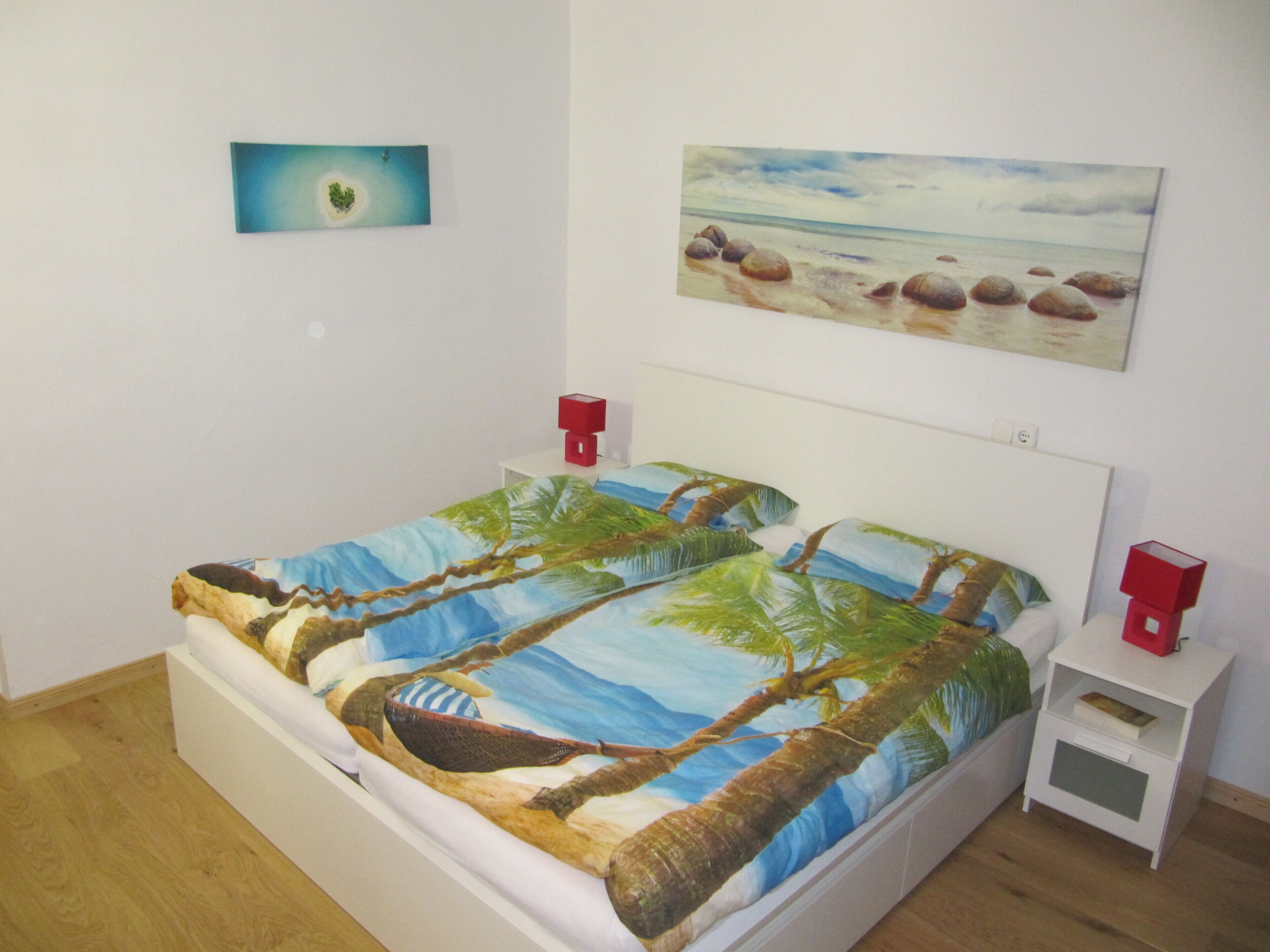Un dormitorio con cama, dos mesitas de noche y decoración en la pared.
