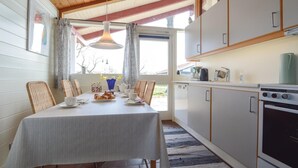 Eine gemütliche Küche mit Essbereich, Holzboden und Blick ins Freie.