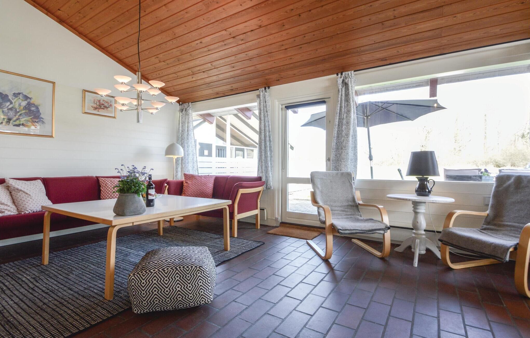 Een gezellige woonkamer met een houten plafond, een zithoek, een salontafel en een eethoek met stoelen en een tafel.