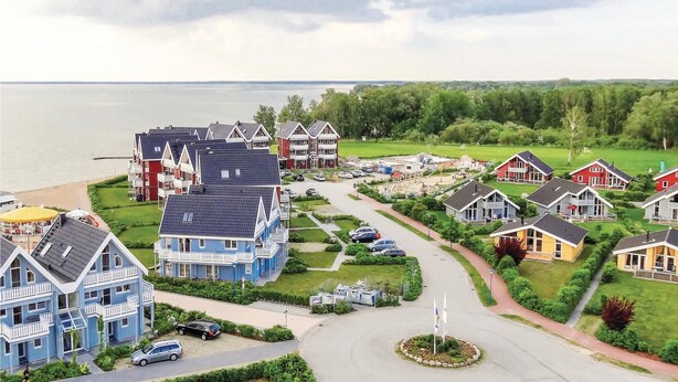 A coastal residential area with multiple houses, a central road, and a body of water in the background. - Stunning home in Rechlin with sauna (Rechlin)