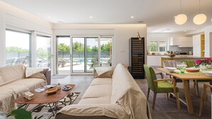 Un salon moderne comprenant un canapé, une table basse et un coin repas avec des chaises et une table.