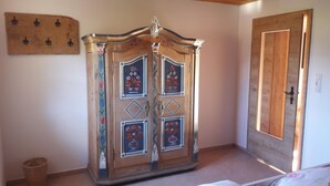 Ein hölzerner Kleiderschrank mit floralen Verzierungen und einem Spiegel.
