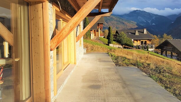 Een houten gebouw met een balkon met uitzicht op een bergachtig landschap.
