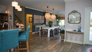 A spacious dining area with a wooden table and chairs, pendant lighting, and a view of the kitchen. - Close to BROADWAY BNA-Gorgeous Home - Idyllic Countryside, Heated Pool & Hot Tub (Mt Juliet)