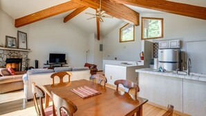 A spacious living area with a wooden dining table, sofas, a fireplace, a television, and a kitchen with a refrigerator and sink. - Lake & Mountain Views Condo - 5 min. drive to lake, ski and golf (Incline Village)