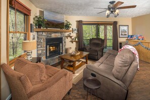 A cozy living room with a fireplace, a sofa, a chair, and a table.