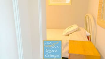 A bedroom with a bed, a bedside table, and a framed picture on the wall.