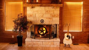 Una chimenea con diseño de estrella, flanqueada por paredes de madera y dos ventanas con persianas.