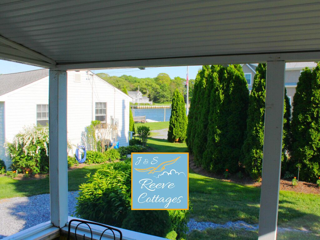 Un porche con vista a una casa blanca y un cartel para J&S Reeves Cottages.