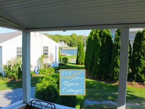 Een terras met uitzicht op een wit huis en een bordje voor J&S Reeves Cottages.