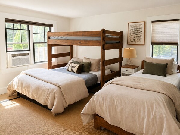 A bedroom with two bunk beds, a bedside table with a lamp, and a window with blinds. - Lake front house about 1 mile from Okemo's Jackson Gore Base Lodge (Ludlow)