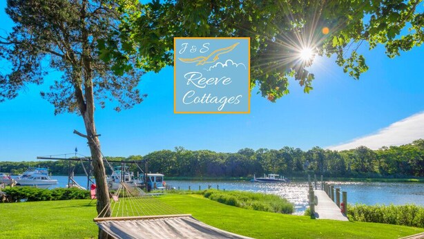 A hammock under a tree by a lake with boats in the background and a sign for J&S Reeves Cottages. - 6th of 6 Premier Waterfront Vacation Rentals on Long Island NY in Wine Country of Famed North Fork (Riverhead)