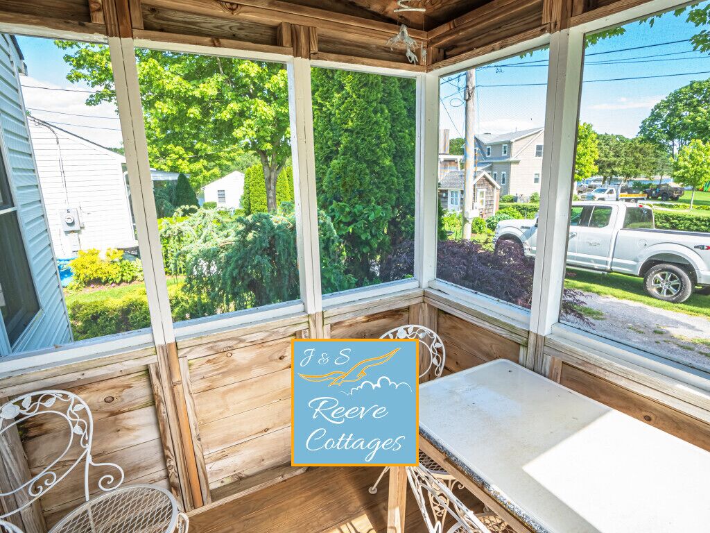 Une pièce aux murs lambrissés, avec une table et des chaises, de grandes fenêtres et une vue sur l’extérieur.