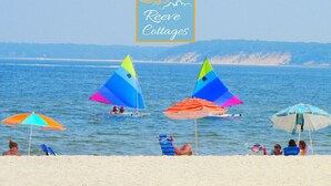A beach scene with colorful kites, umbrellas, and people relaxing on the sand. - 6th of 6 Premier Waterfront Vacation Rentals on Long Island NY in Wine Country of Famed North Fork (Riverhead)