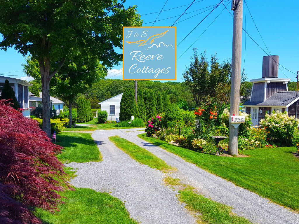 A sign for J&S Reeves Cottages with a gravel driveway leading to a row of houses.