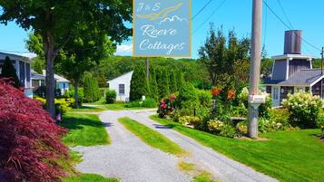 A sign for J&S Reeves Cottages with a gravel driveway leading to a row of houses.