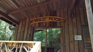 L’entrée d’un chalet en bois, sur laquelle est apposée une pancarte indiquant « WILD ROCK ».