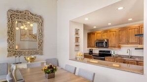 A modern kitchen with wooden cabinets, a stainless steel microwave, and a granite countertop.
