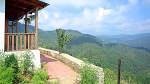 A wooden structure with a balcony overlooking a lush valley. - Banlekhi (Dhari)
