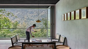 Un intérieur moderne avec un balcon donnant sur un paysage montagneux.