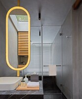 Une salle de bain moderne avec un grand miroir, une baignoire, une douche et un meuble-lavabo avec des articles de toilette.