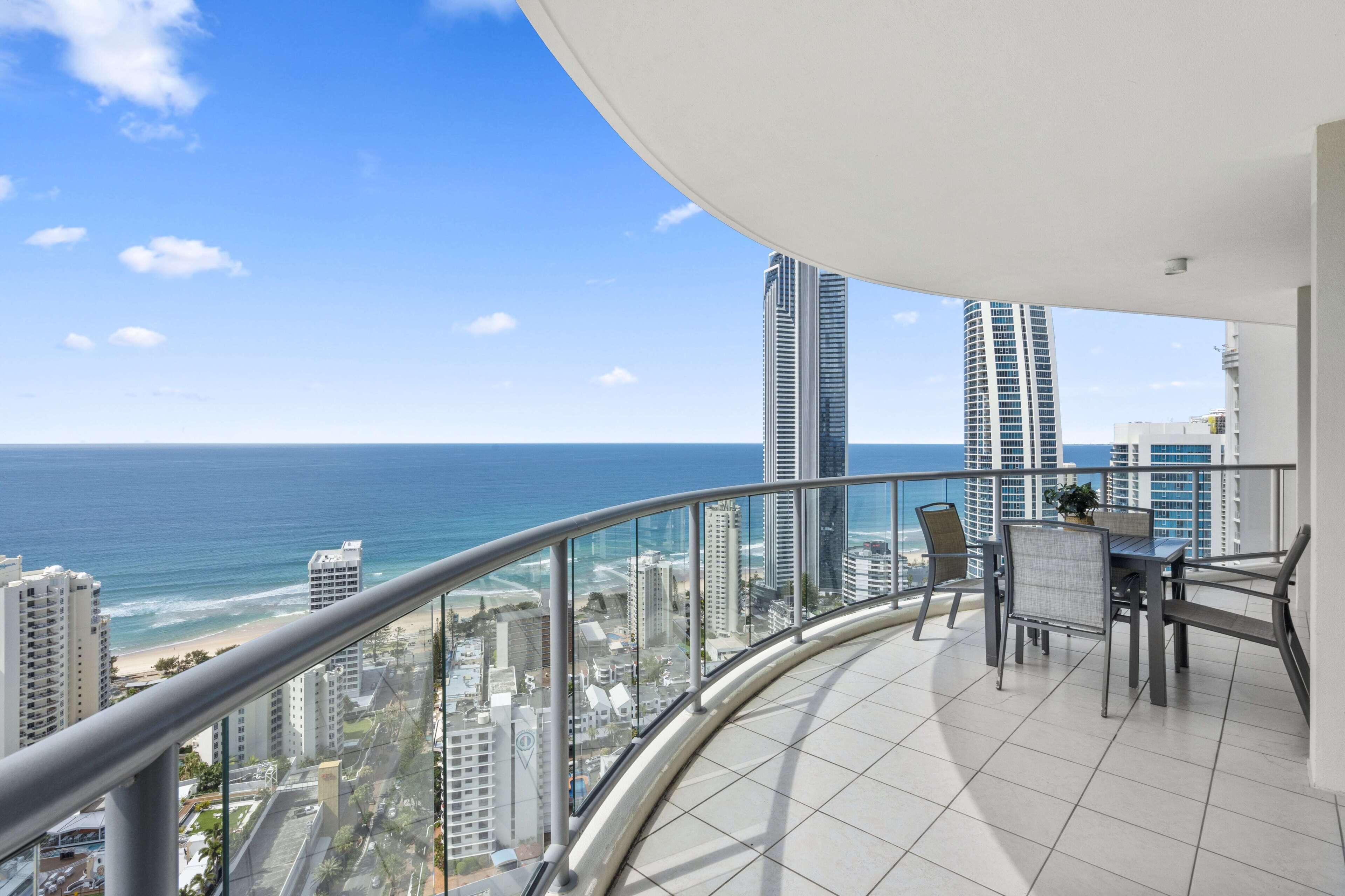Ein Balkon mit Blick auf das Meer und hohe Gebäude.