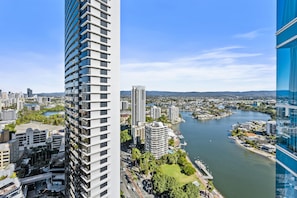 A high-rise building with a river view, surrounded by other buildings and greenery. - Chevron Renaissance - Q Stay (Surfers Paradise)