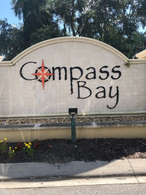 A sign with the words "Compass Bay" and a compass symbol.