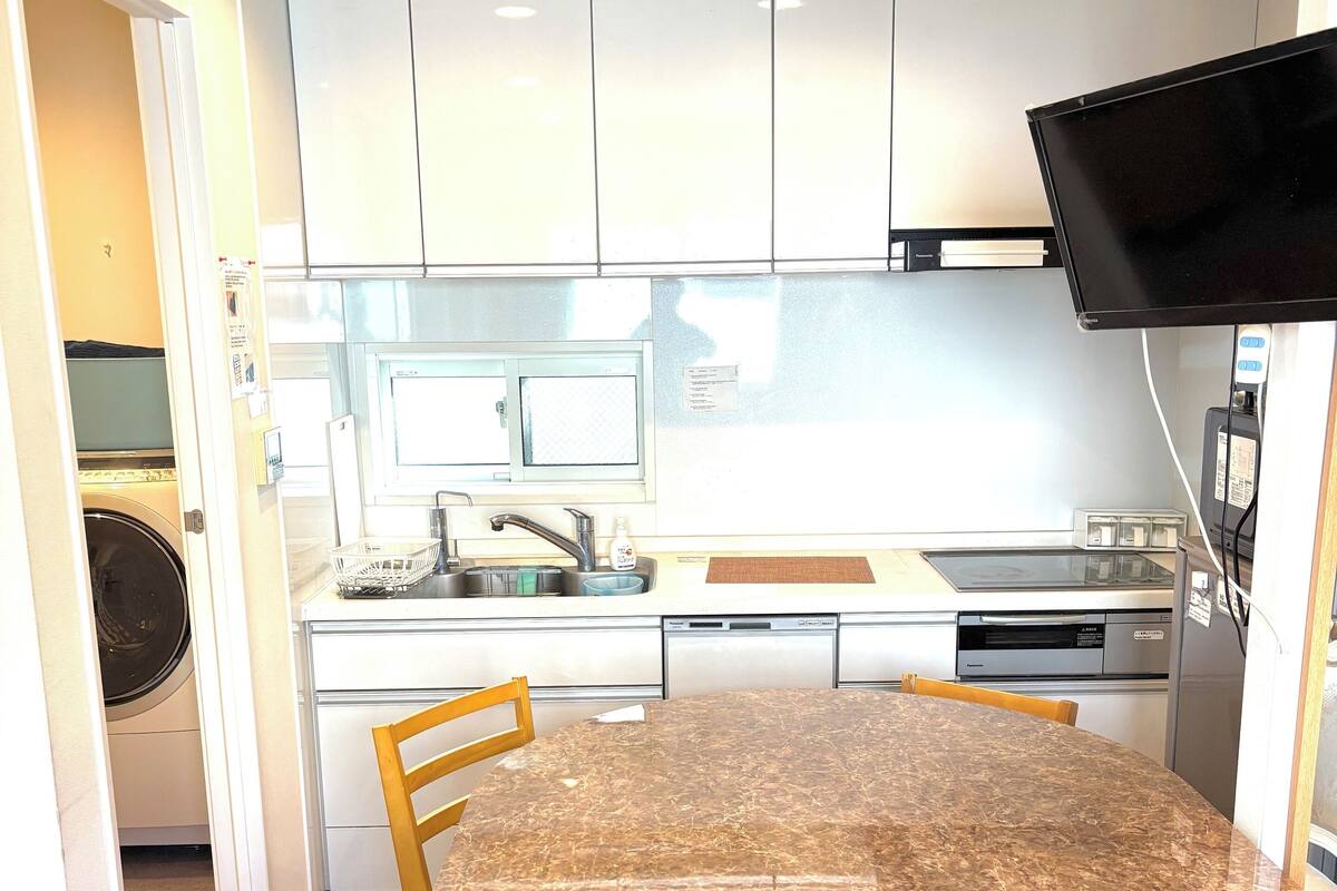 A modern kitchen with white cabinets, a granite countertop, and a built-in oven.