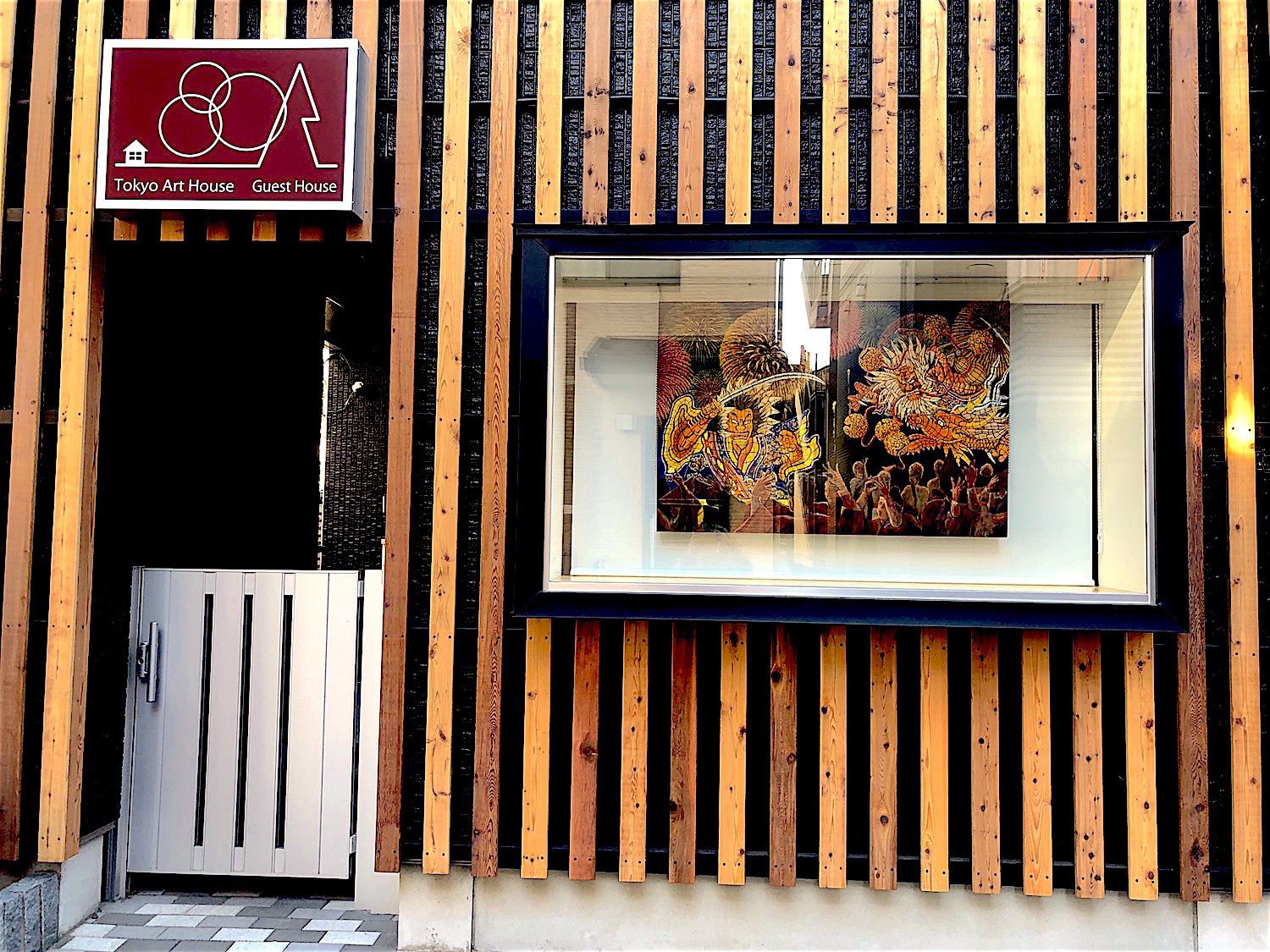 A wooden facade with a framed artwork of a traditional scene.