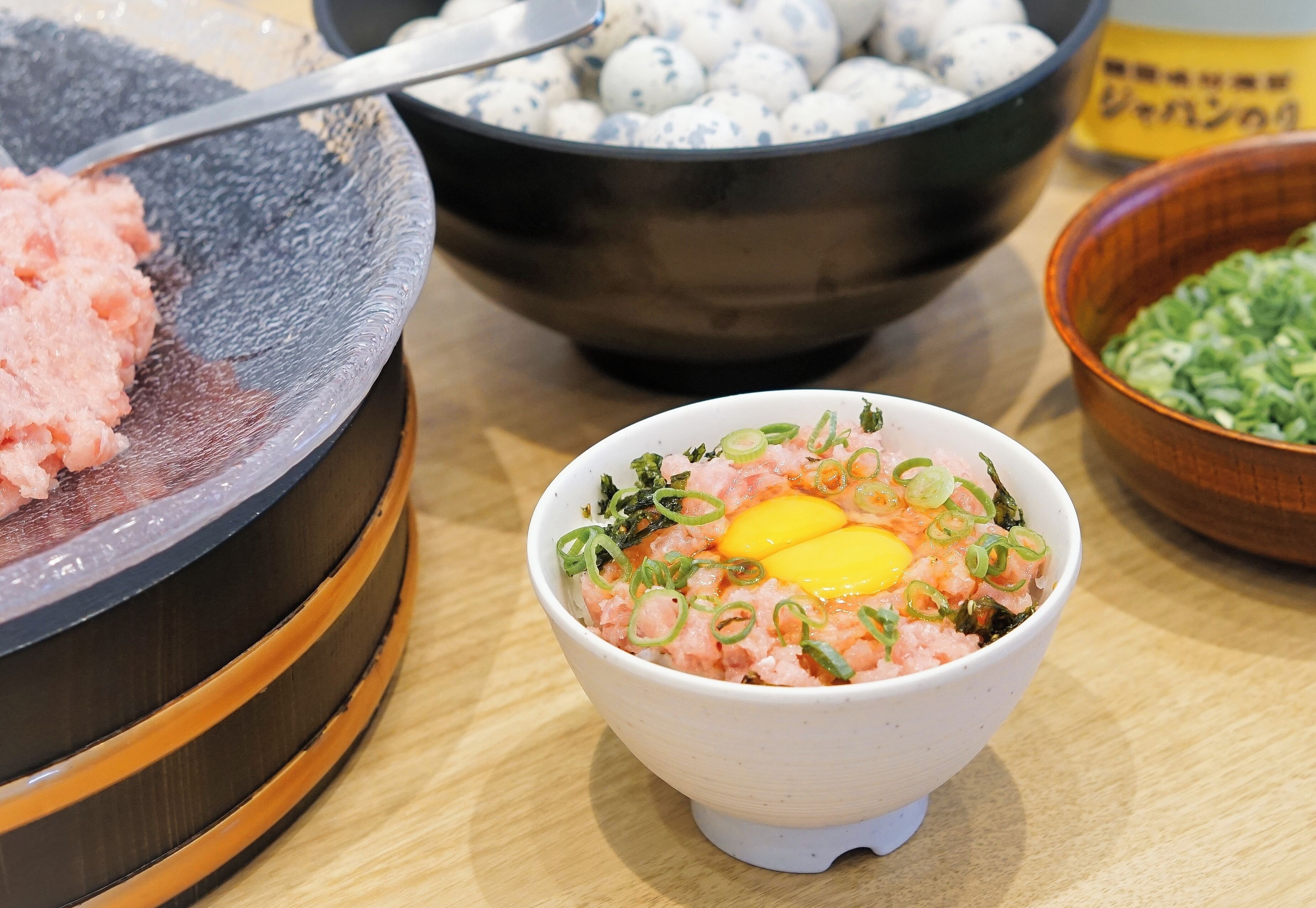 A bowl of food with green onions and an egg on top.
