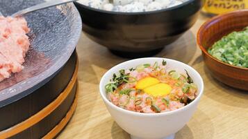 A bowl of food with green onions and an egg on top.