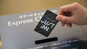 Une main tenant une carte sur laquelle est écrit « JUST INN ».