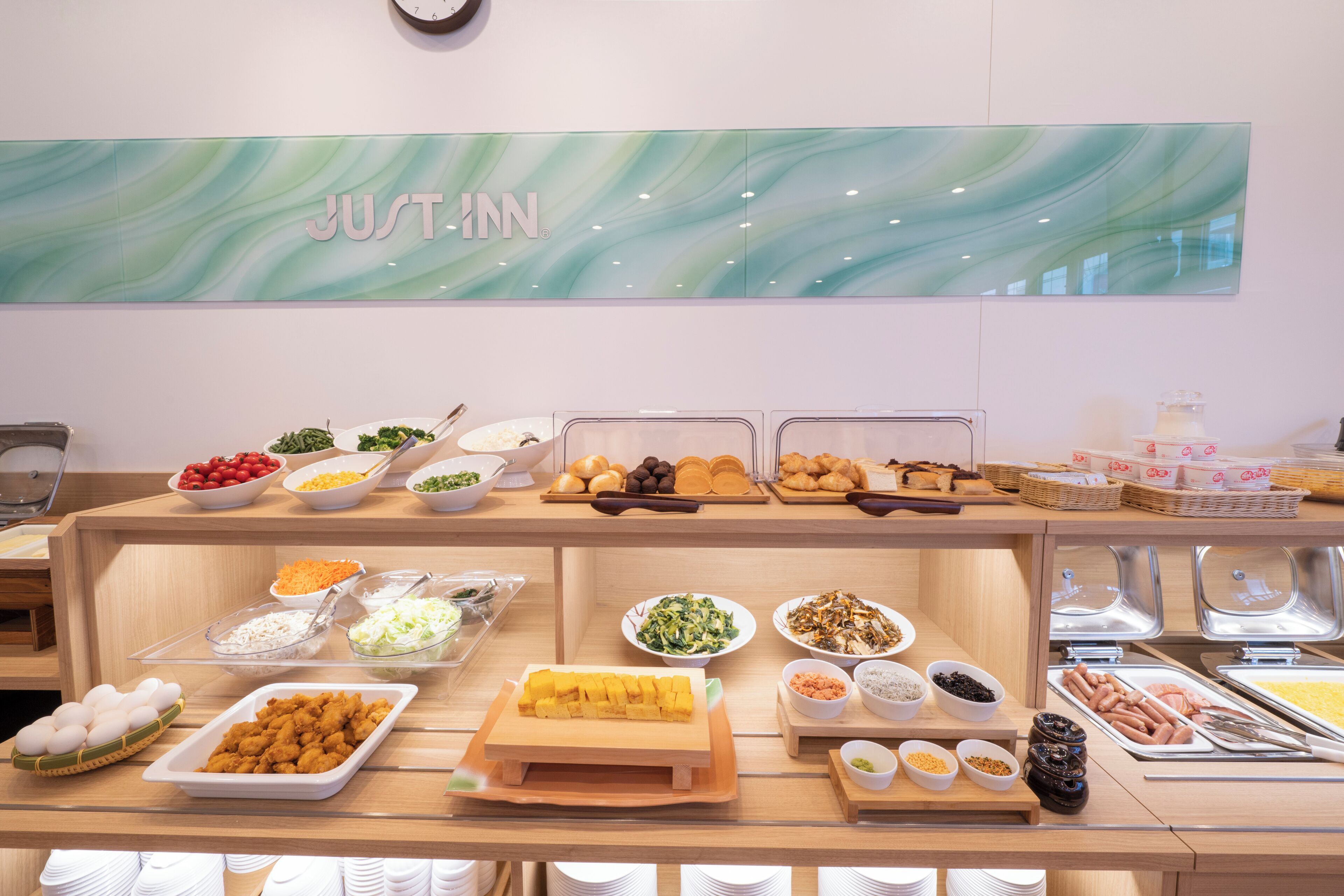 Un mostrador de buffet con diferentes alimentos y un letrero que dice 'RECIÉN ARRIVADO'.