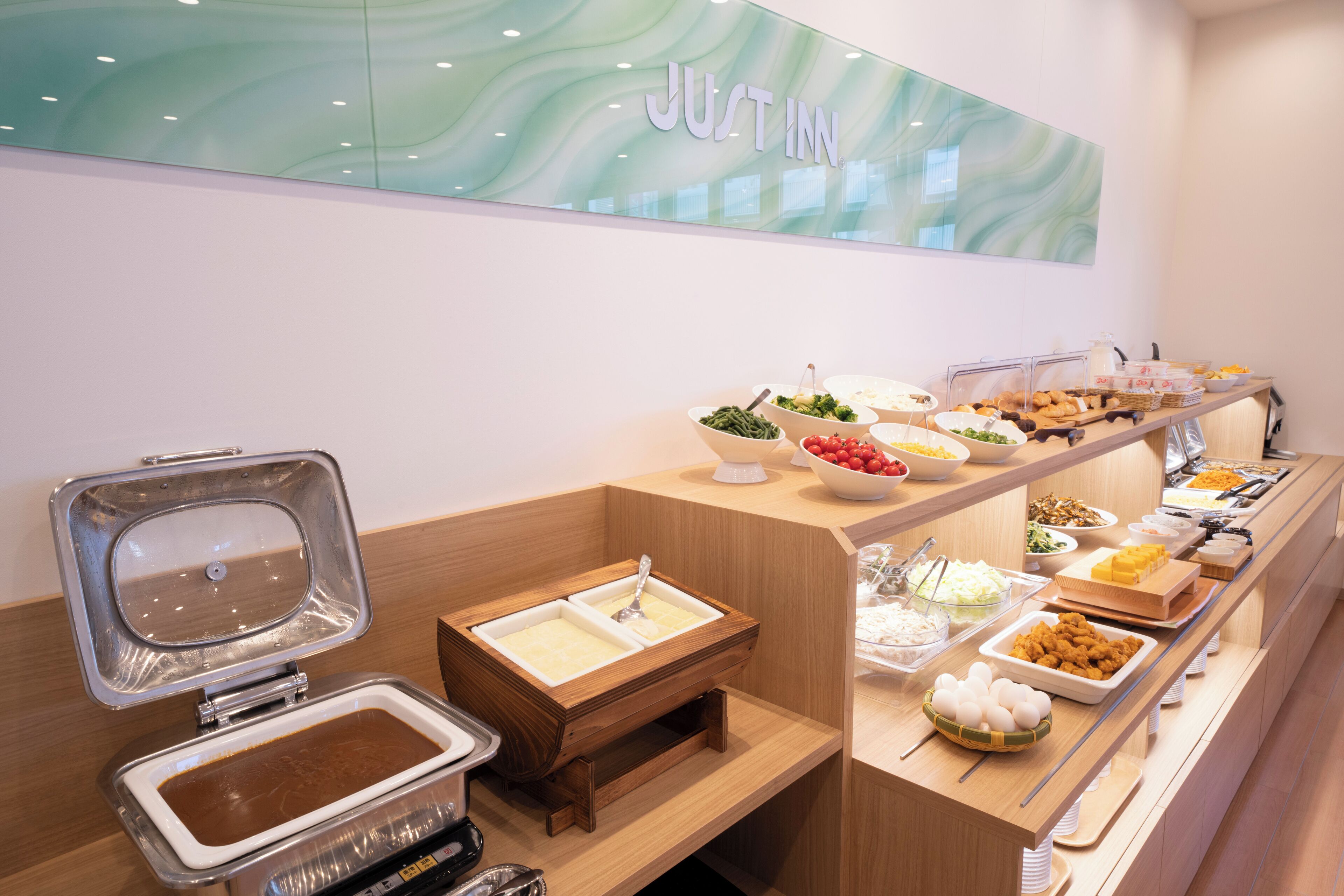A buffet setup with various food items and a sink area.