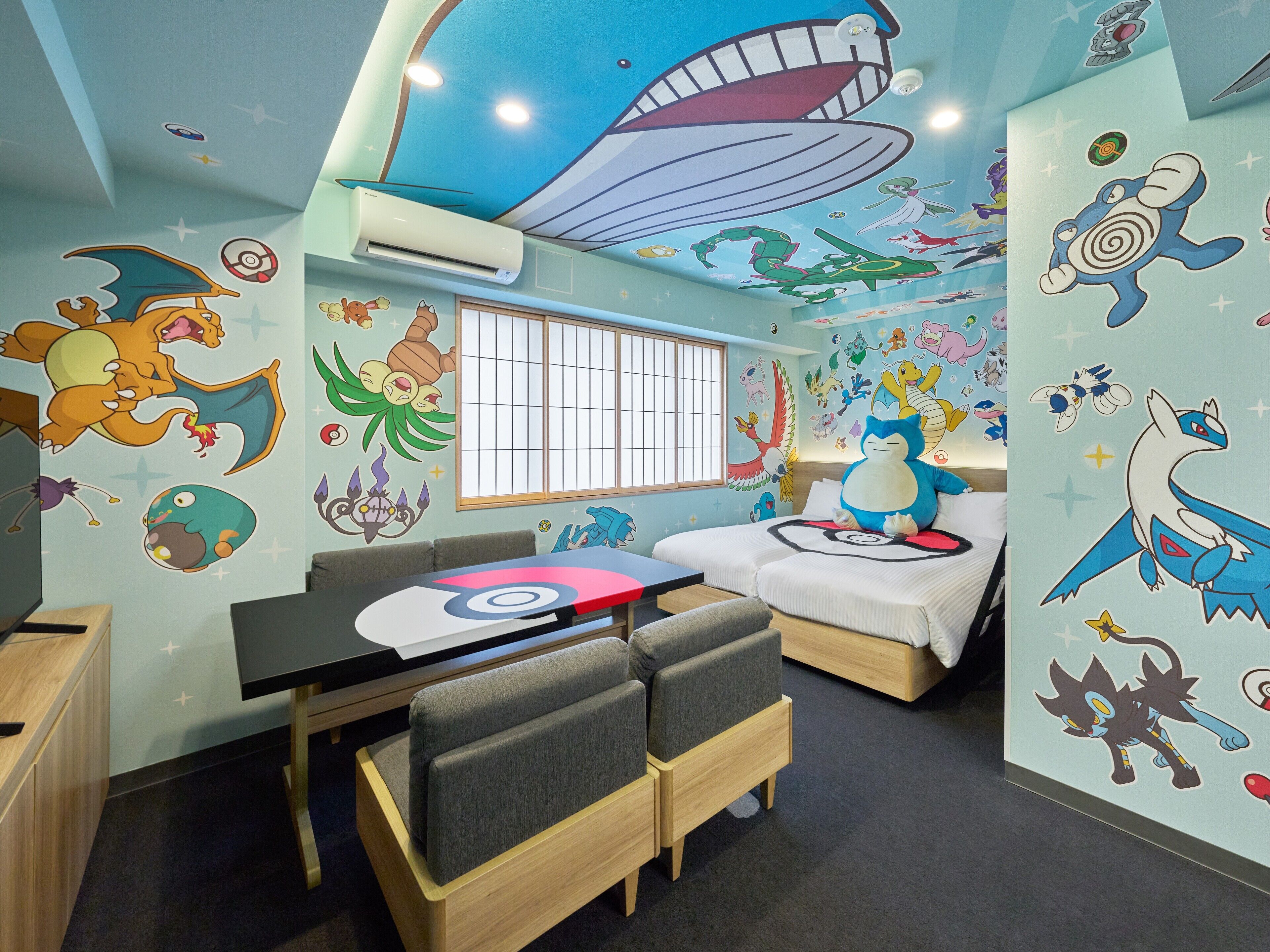 A children's room with a bunk bed, a desk, and a window.