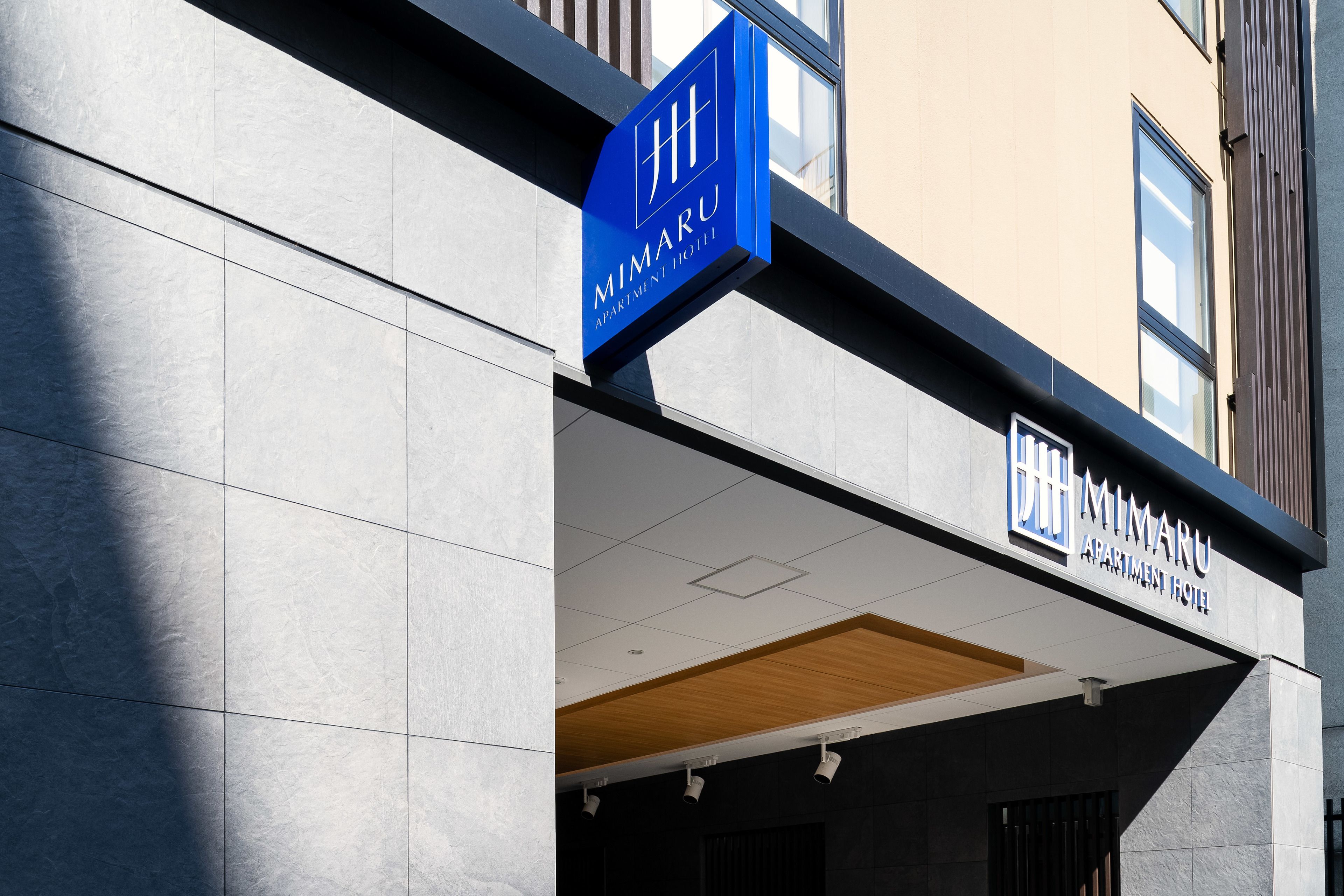 A modern building with a sign for 'MIMARU APARTMENT HOTEL'.