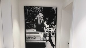 A hallway with a framed black and white photograph of a vintage car and a wicker basket on the floor. - Bergblick Riedlern, Kreuth Riedlern - Mountain View Riedlern - Apartment (Kreuth)