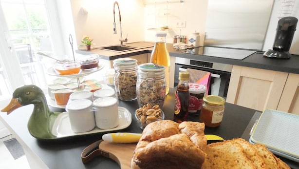 Una encimera de cocina con pan, frascos y electrodomésticos.