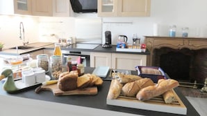 Una cocina moderna con armarios de madera, un microondas negro y un reloj en la pared.