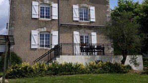 A two-story building with a balcony and a staircase leading to the upper floor.